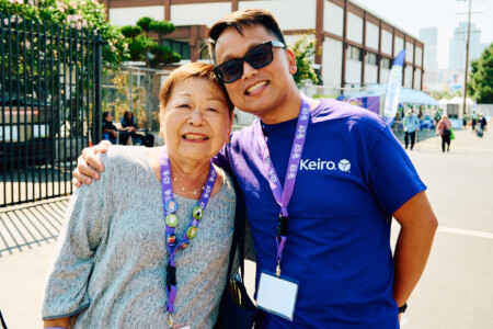 M PALMA PHOTO 2025 woman in grey shirt and man in purple Keiro shirt smiling