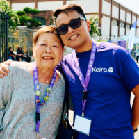 M PALMA PHOTO 2025 woman in grey shirt and man in purple Keiro shirt smiling