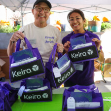 man in glasses and woman in glasses holding purple bags