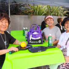 three woman sitting at a green table