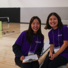 two woman in purple t shirts smiling