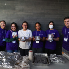 group of people holding bentos and smiling