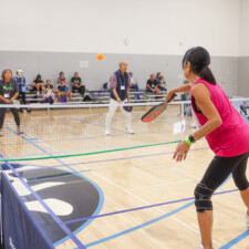 a woman serving a pickleball