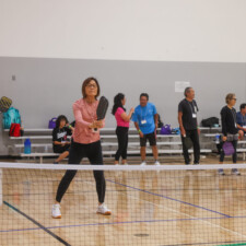 woman in a pink shirt holding onto paddle