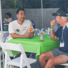 a man with an orange ball talking to man in blue