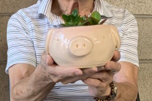 Here Little Piggy - Ben Tsuchida (91) Man holding pig plant pot