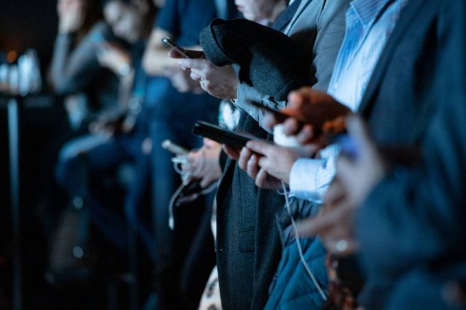 men with suits all looking on their smartphone