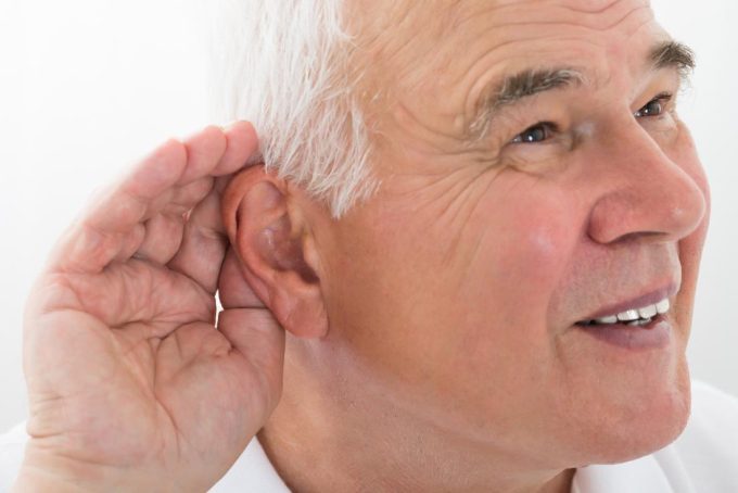 man cupping ear