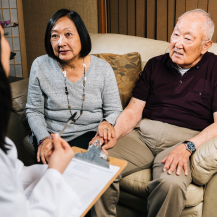 doctor seeing older adult and caregiver