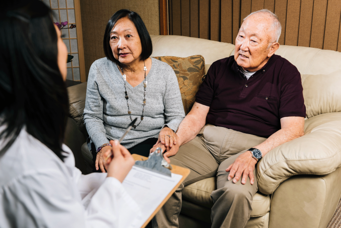 doctor seeing older adult and caregiver