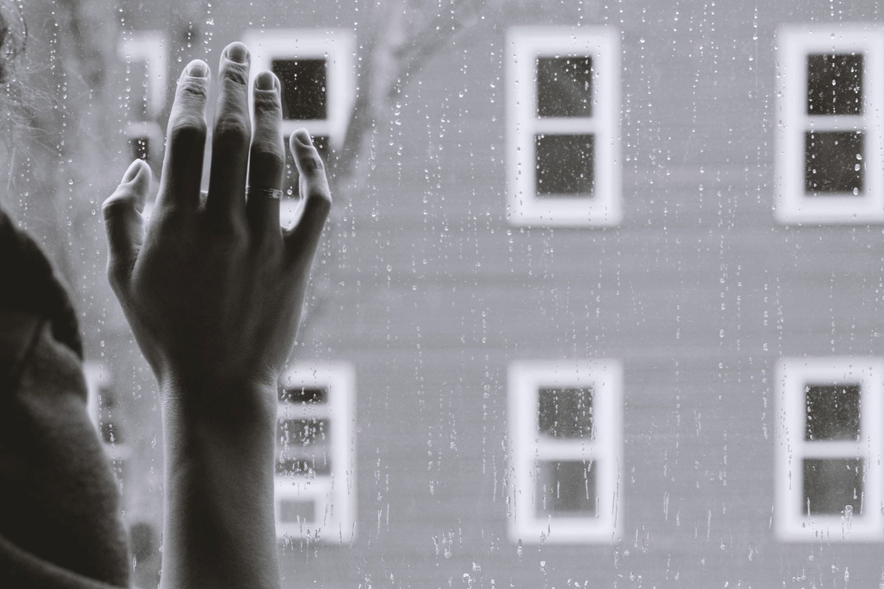 rain falling outside with a hand on a window