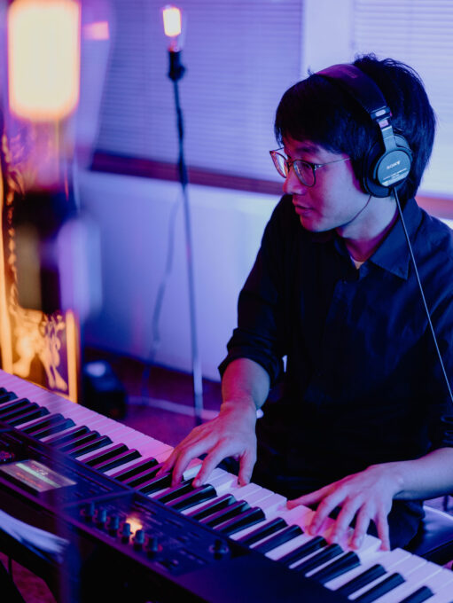 man with headphones on playing piano