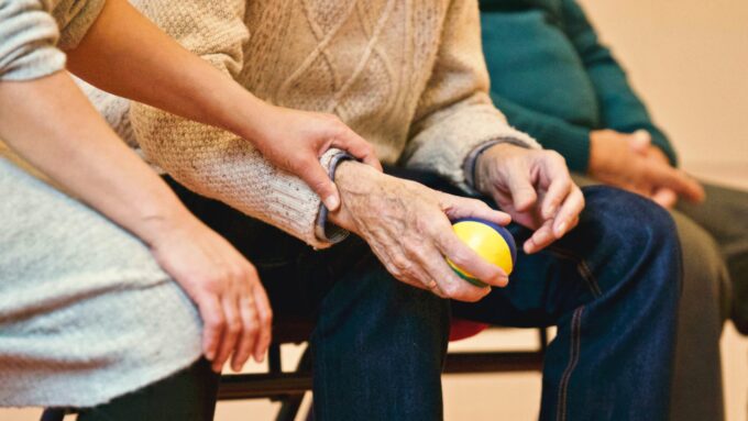 older adult hands and caregiver hands